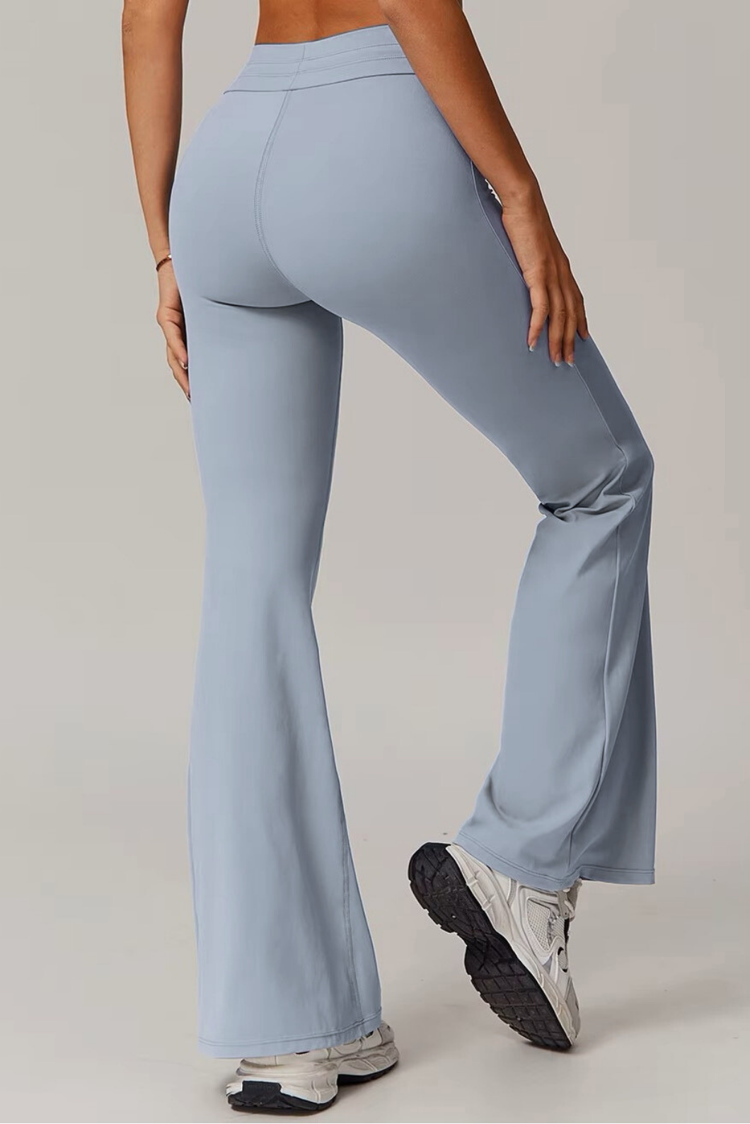 Light blue grey flared pants worn by a person on a plain background