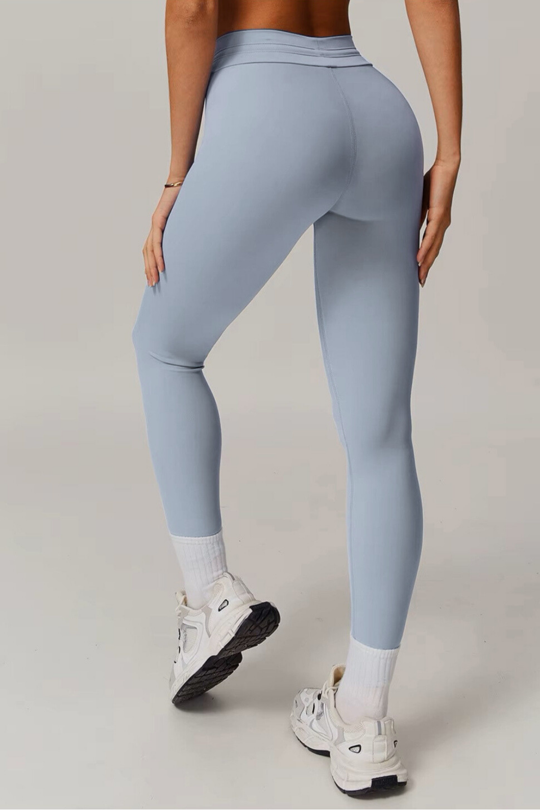 Light blue grey leggings worn by a person on a plain background