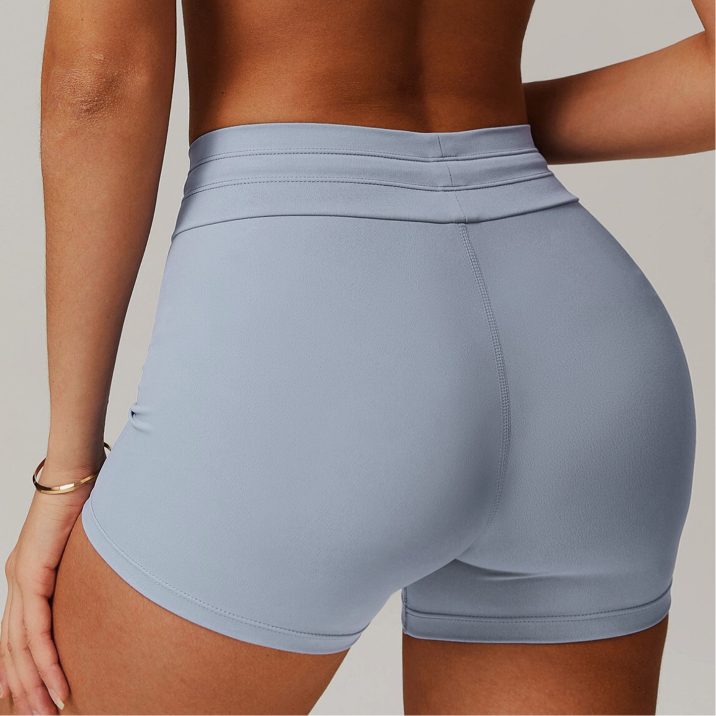 Light blue grey athletic shorts worn by a person on a neutral background