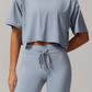 Person wearing a light blue grey athletic outfit on a neutral background
