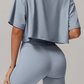Person wearing a light blue grey athletic outfit on a neutral background