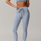 Person wearing a light blue grey athletic outfit on a plain background