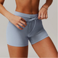Light blue grey athletic shorts worn by a person on a neutral background