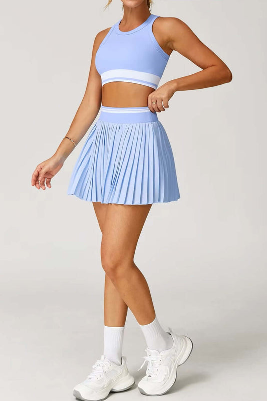 Person wearing a light blue athletic outfit with a skirt on a plain background