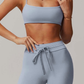 Person wearing a light blue grey sports bra and leggings on a plain background